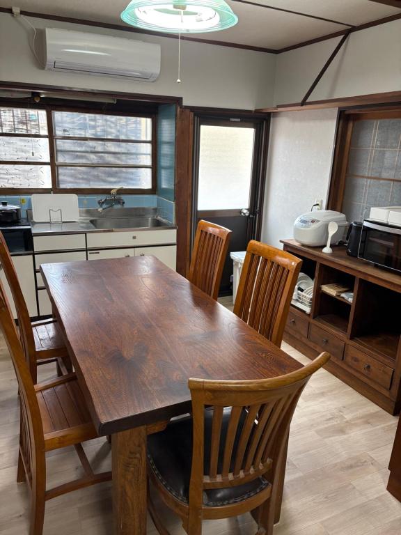 a kitchen with a wooden table and chairs at 日牟禮乃宿 日牟禮八幡宮徒歩4分ラコリーナ車4分 in Omihachiman