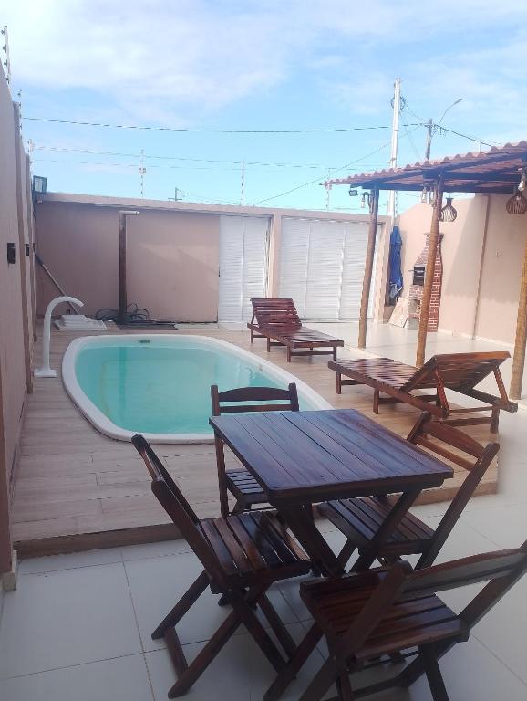 a pool on a deck with chairs and a table at Casa completa in Marechal Deodoro