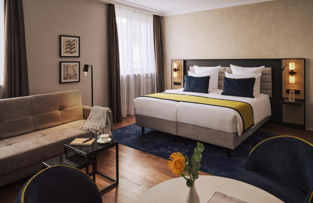 a hotel room with a bed and a couch at Hotel Mannheimer Hof - Leonardo Limited Edition in Mannheim