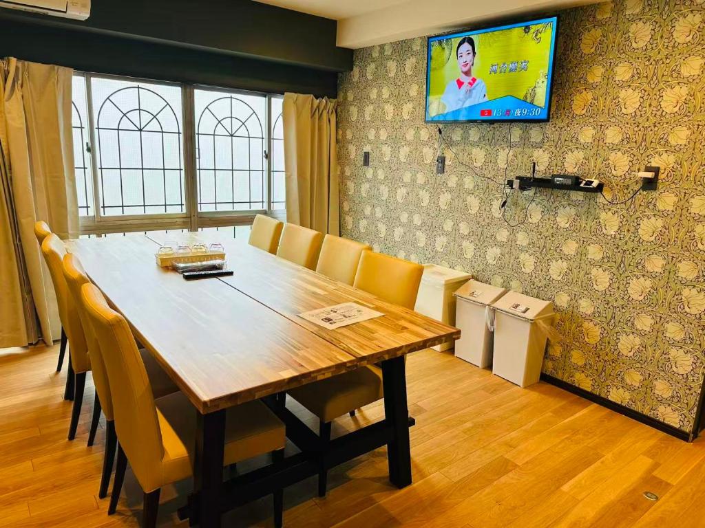 a dining room table with chairs and a television on the wall at Vacances Skytree Plaza in Tokyo