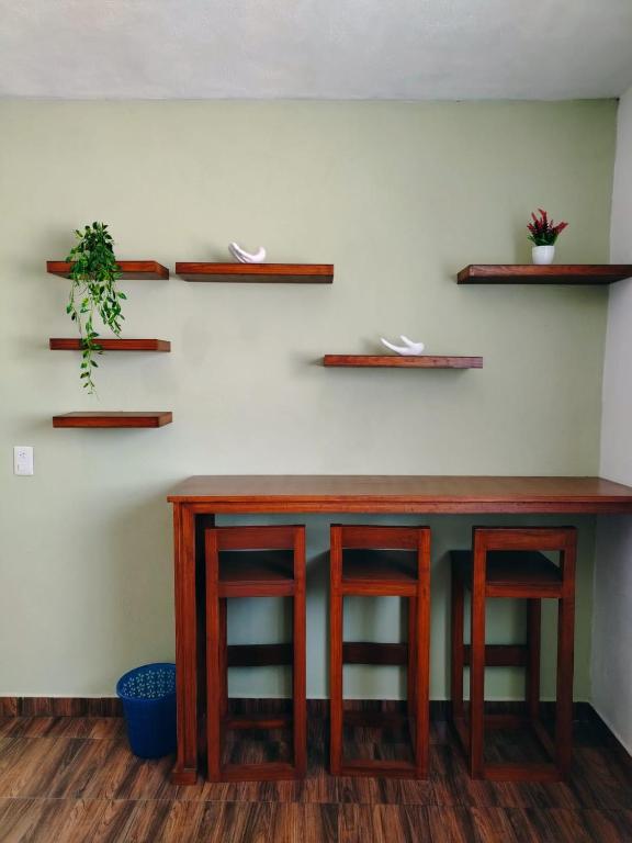 a bar with two stools and shelves on a wall at La Casa de Lu cerca de Volcanic park in San Martín Ojo de Agua
