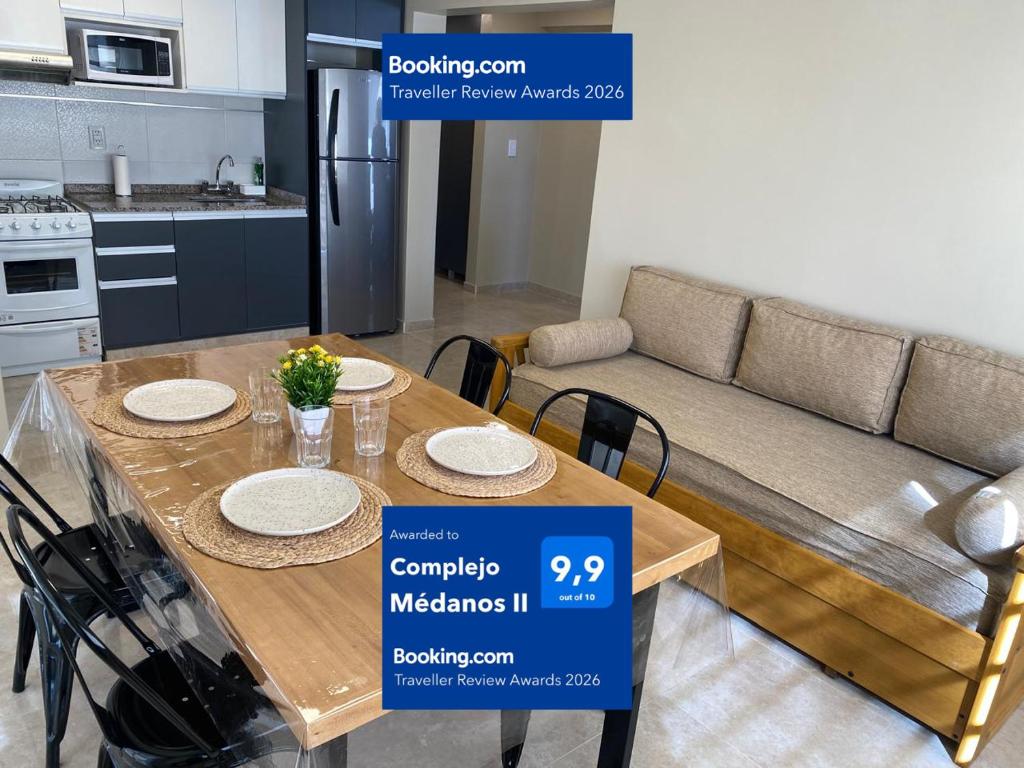 a kitchen and dining room with a table and a couch at Complejo Médanos II in San Bernardo