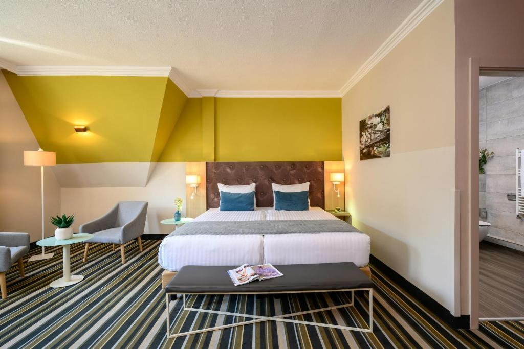a hotel room with a bed and a desk at Leonardo Hotel Budapest in Budapest