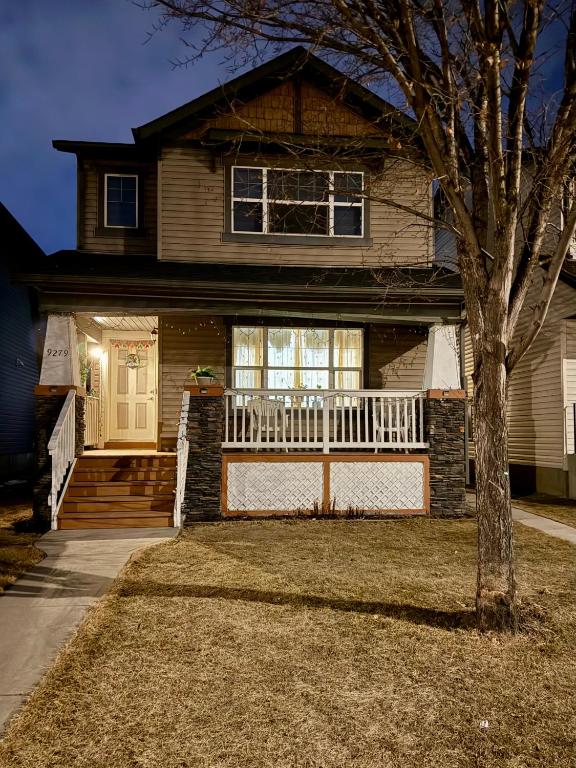 a house with a porch and a white fence at Cozy 1-Bed Basement Suite in Calgary