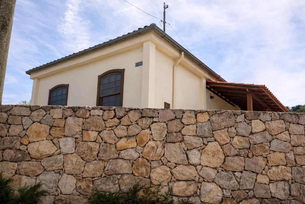 a house behind a stone wall at Casa vila carolla in Tiradentes