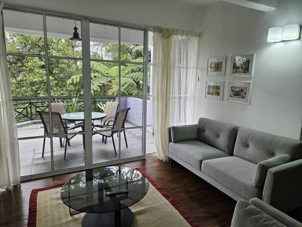 a living room with a couch and a table at Fraser's Haven SilverparkResort Walk down 8 steps in Bukit Fraser