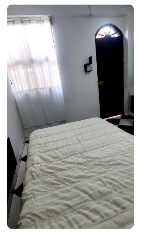 a bedroom with a bed and a window and a door at Sunset bed in Puerto Chicama