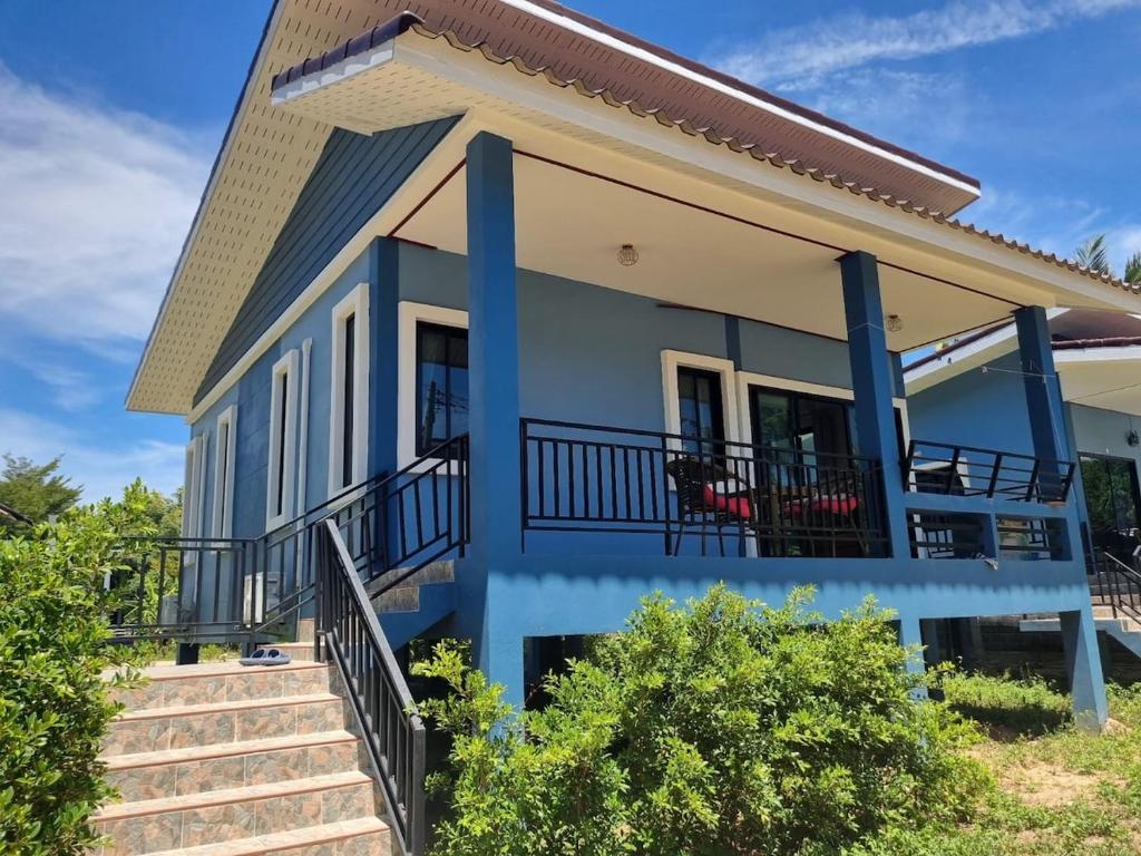 a house with blue trim and stairs in front at Very Central Boho Home in Srithanu in Ko Kong Nui