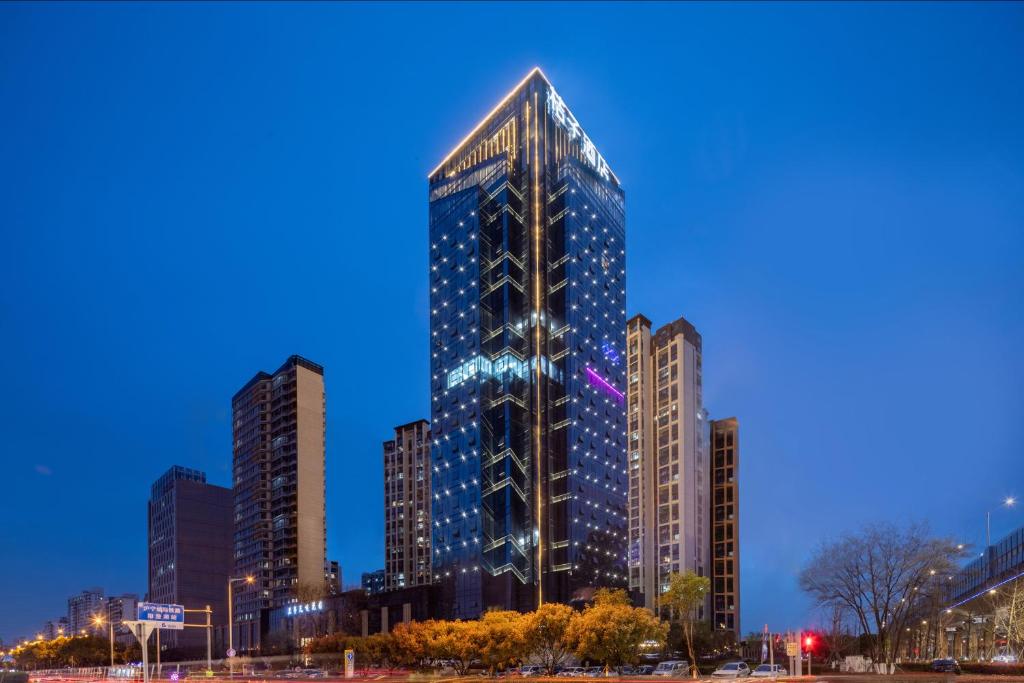 a tall building in a city at night at Orange Hotel Kunshan MixC Hotel in Kunshan