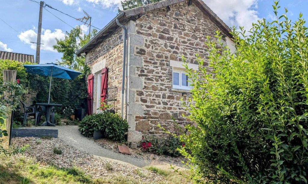 a stone house with a red door and a garden at La parenthèse bucolique in Cheissoux