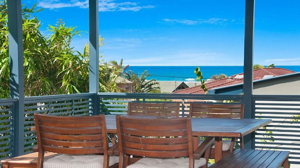 a table and chairs on a balcony with a view of the ocean at KK s in Lennox Head in Lennox Head