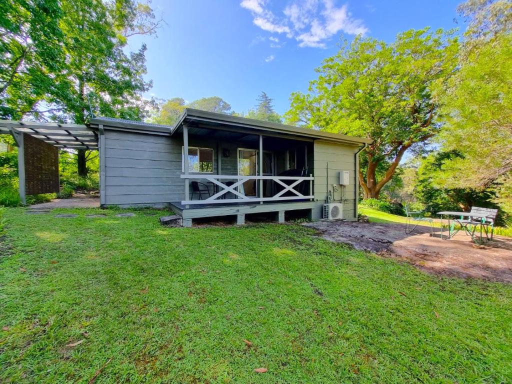 a small house with a lawn in front of it at Norman Lindsay Cottage in Faulconbridge