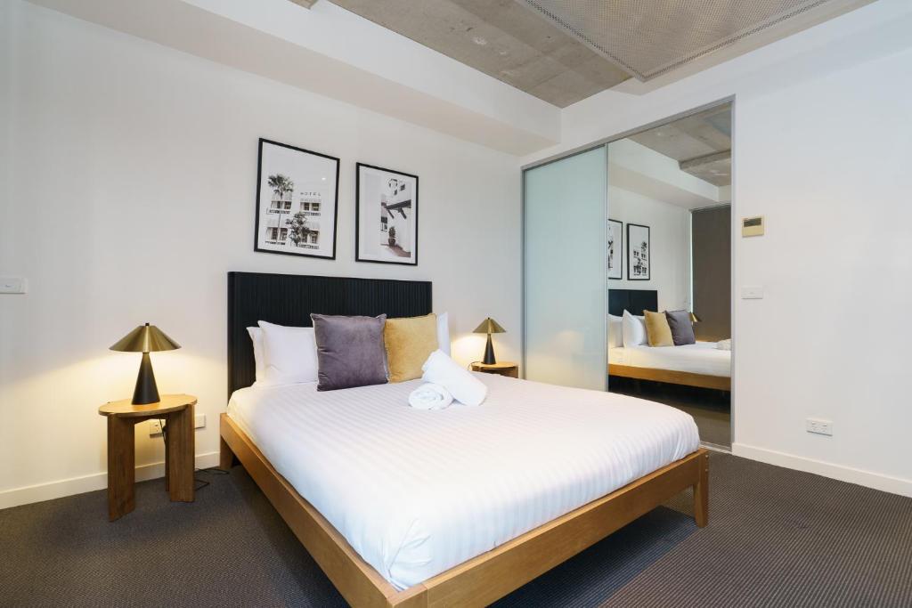 a bedroom with a large white bed with two lamps at Spacious Studio in a Prime Braddon Location - Hosted by Canstay in Braddon