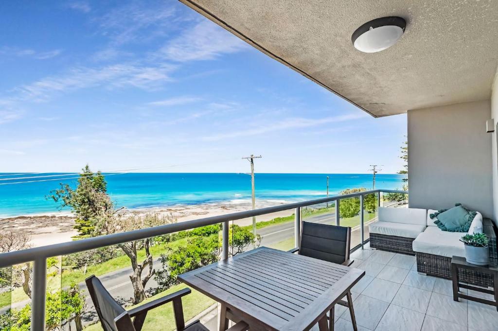a balcony with a table and chairs and the ocean at Surf Sea and Sand in East Ballina