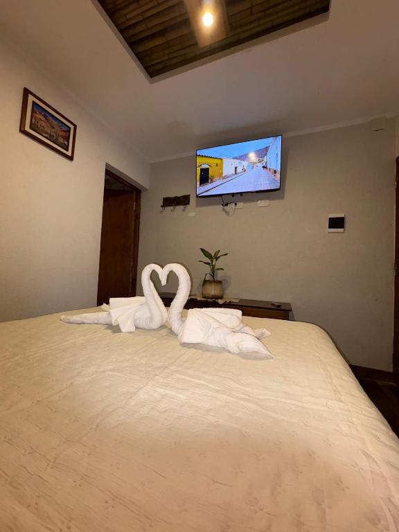 two swans made out of towels sitting on a bed at Casa Nuna in Tilcara