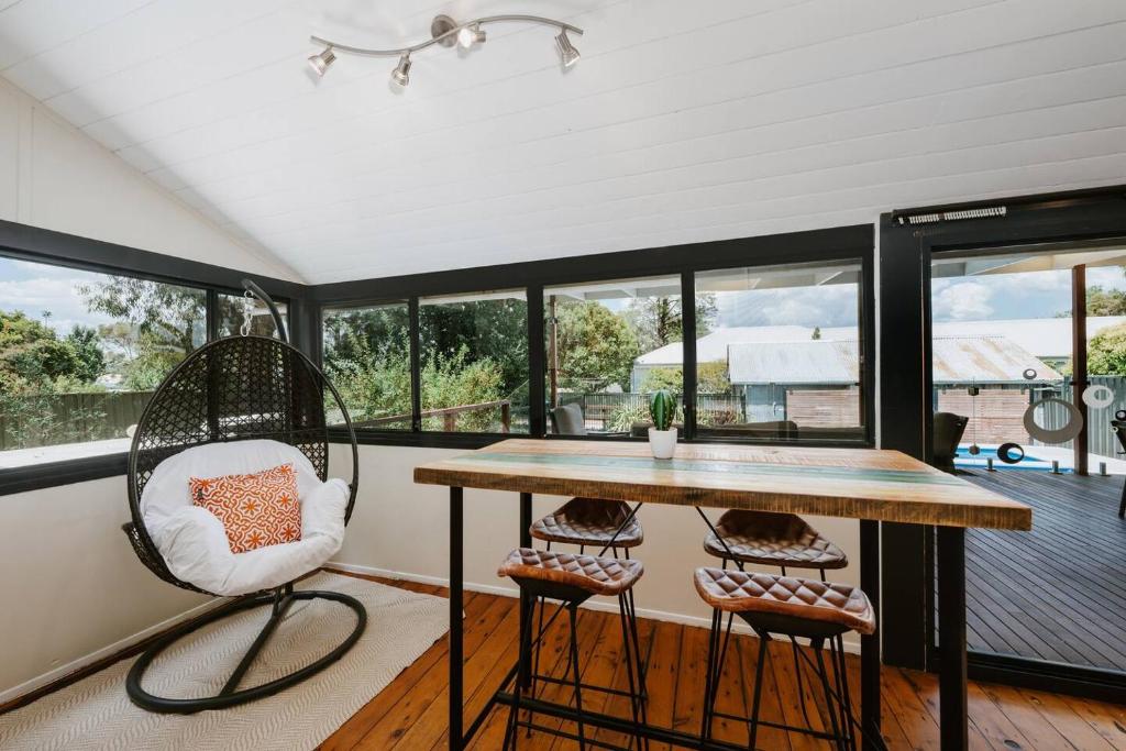 a screened in porch with a table and two chairs at Ironbark Oasis - Serene Poolside Haven by Mudgee CBD in Mudgee