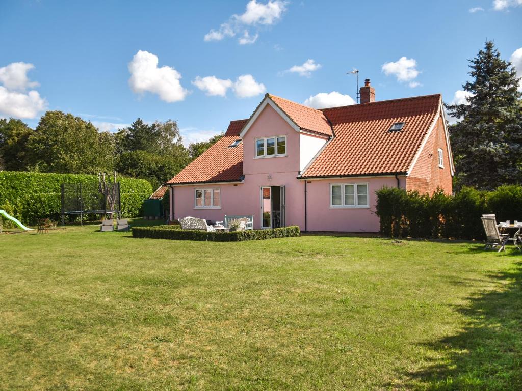 a pink house with a yard in front of it at Green Farm Cottage in Redgrave