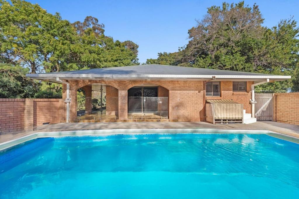 a swimming pool in front of a house at Coorabell House in Ewingsdale
