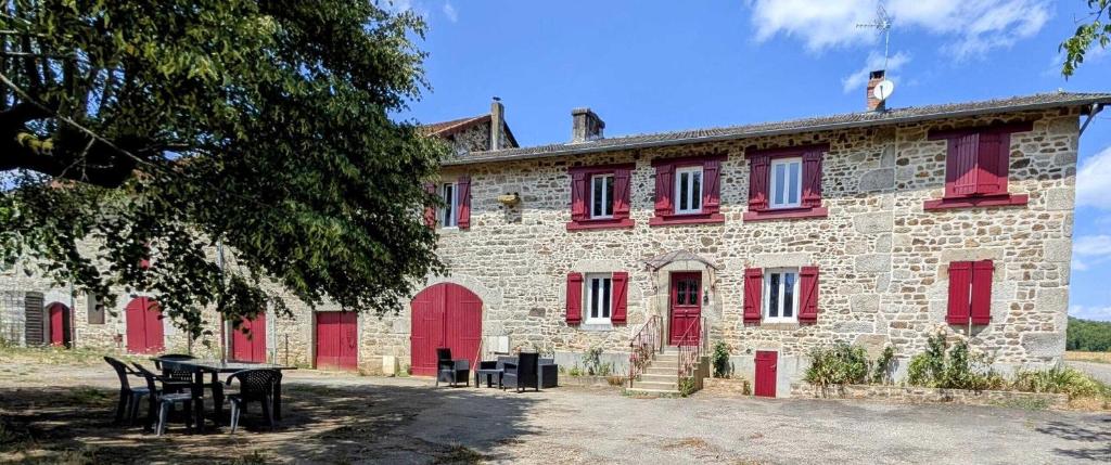 a building with red doors and a table in front of it at Villetelle in Cheissoux