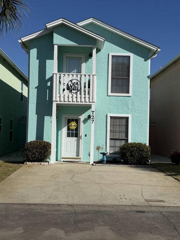 a blue house with a balcony on the front at Sea the Good in Panama City Beach