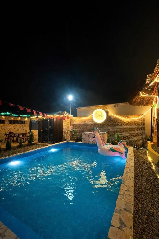 a swimming pool at night with a float in the water at Charming - attractive - pristine nature - peaceful in Vũ Lâm