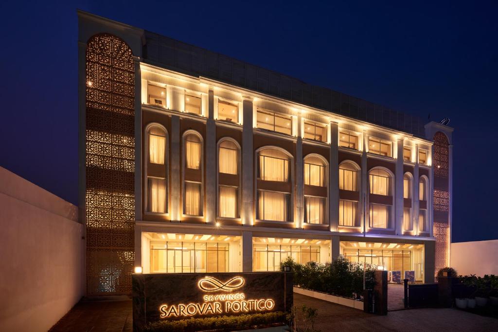 a large building with a sign in front of it at Skywings Sarovar Portico Mathura in Mathura