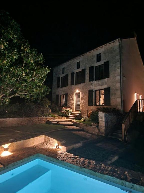a house at night with a swimming pool in front of it at House And Playful Barn in Verrières