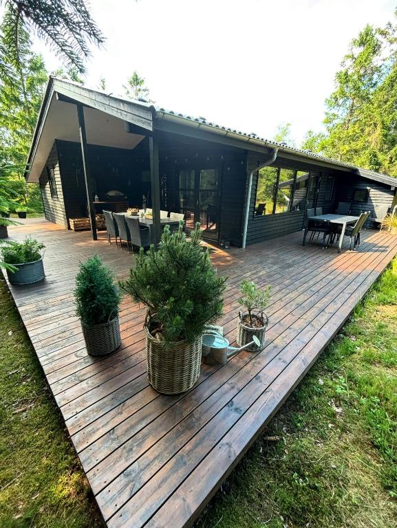 a wooden deck with potted plants in front of a house at Summer House 300 M From Beach in Hals