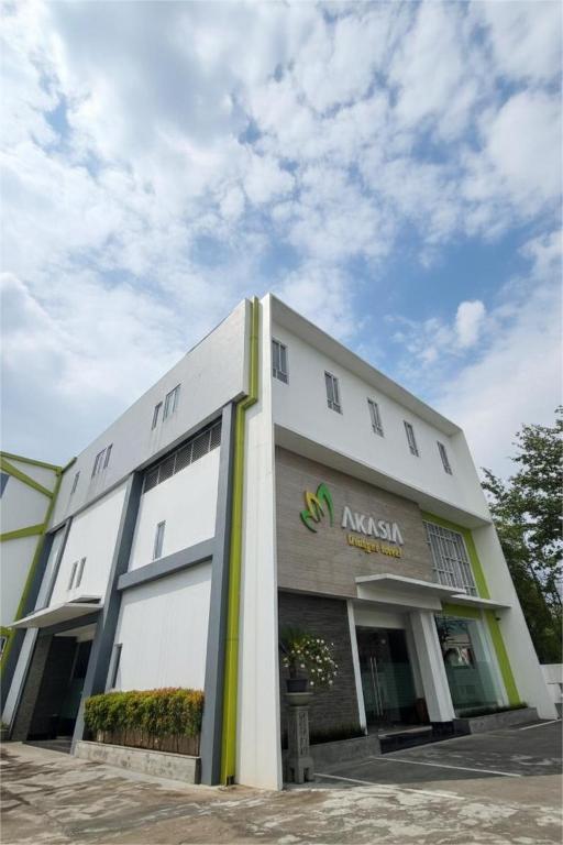 a large white building with a sign on it at Akasia Budget Hotel in Ulujami