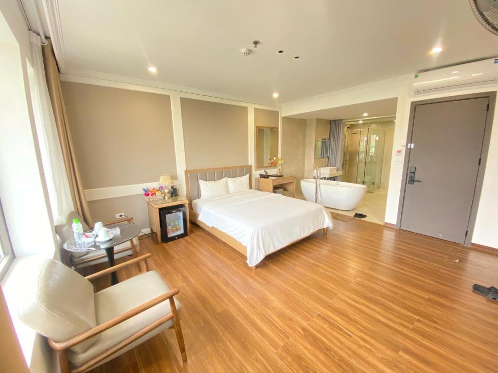 a bedroom with a bed and a bathroom with a tub at Nhật Tân Hotel Hà Nội - Lê Trọng Tấn in Hanoi