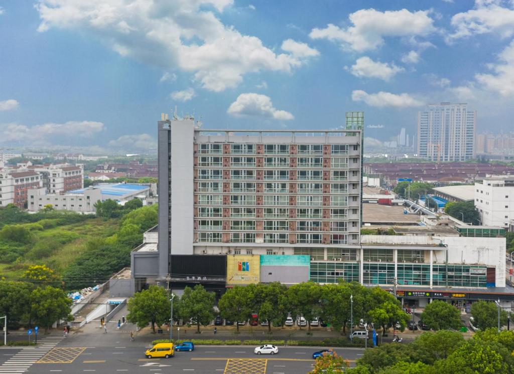 a large building in a city with a parking lot at JI Hotel Suzhou Wujiang Development Zone in Suzhou