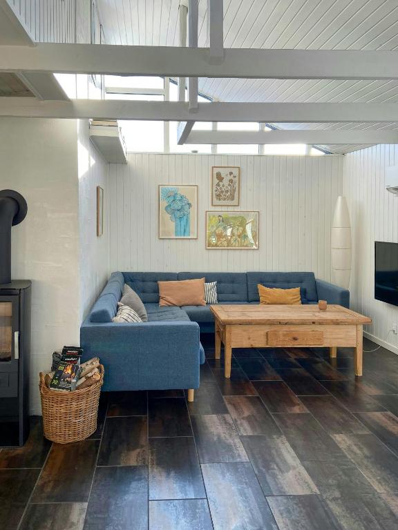 a living room with a blue couch and a coffee table at Architect-Designed Cottage By The Water in Middelfart