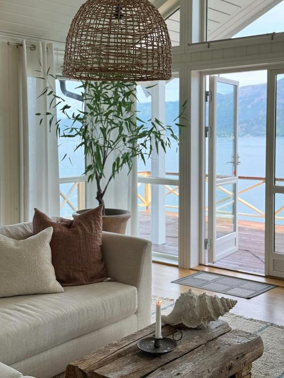a living room with a couch and a potted plant at Northern Lights View Cabin With Big Veranda in Ballangen