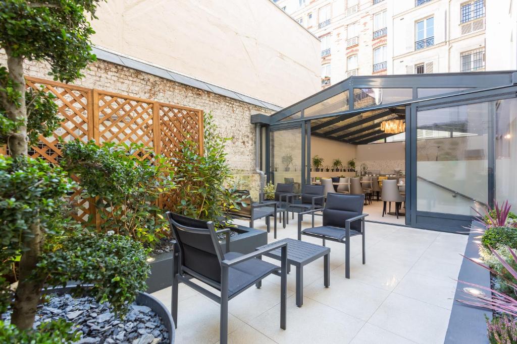 an outdoor patio with black chairs and tables at Jardin de Villiers in Paris