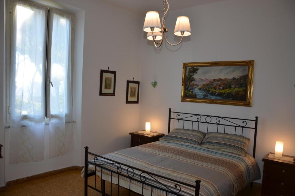 una camera da letto con un letto con due lampade e una finestra di Casa Lia a Marina di Carrara