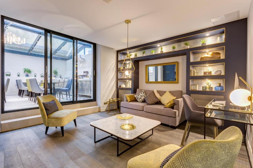 a living room with a couch and chairs and a table at Jardin de Villiers in Paris