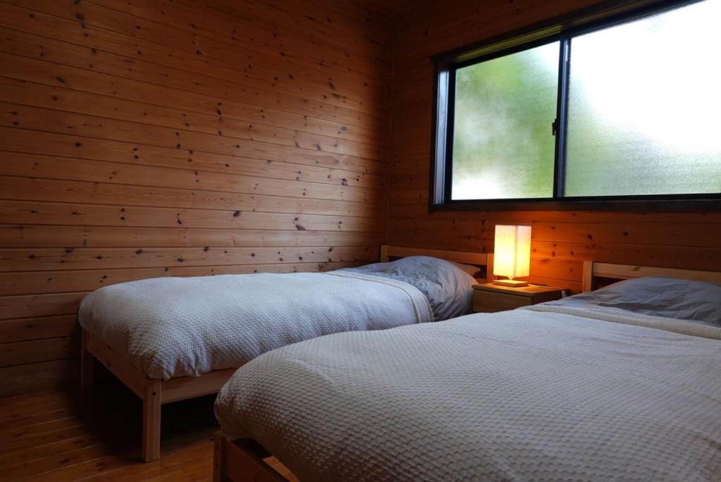 a bedroom with two beds and a window in it at コテージZen in Kyotango