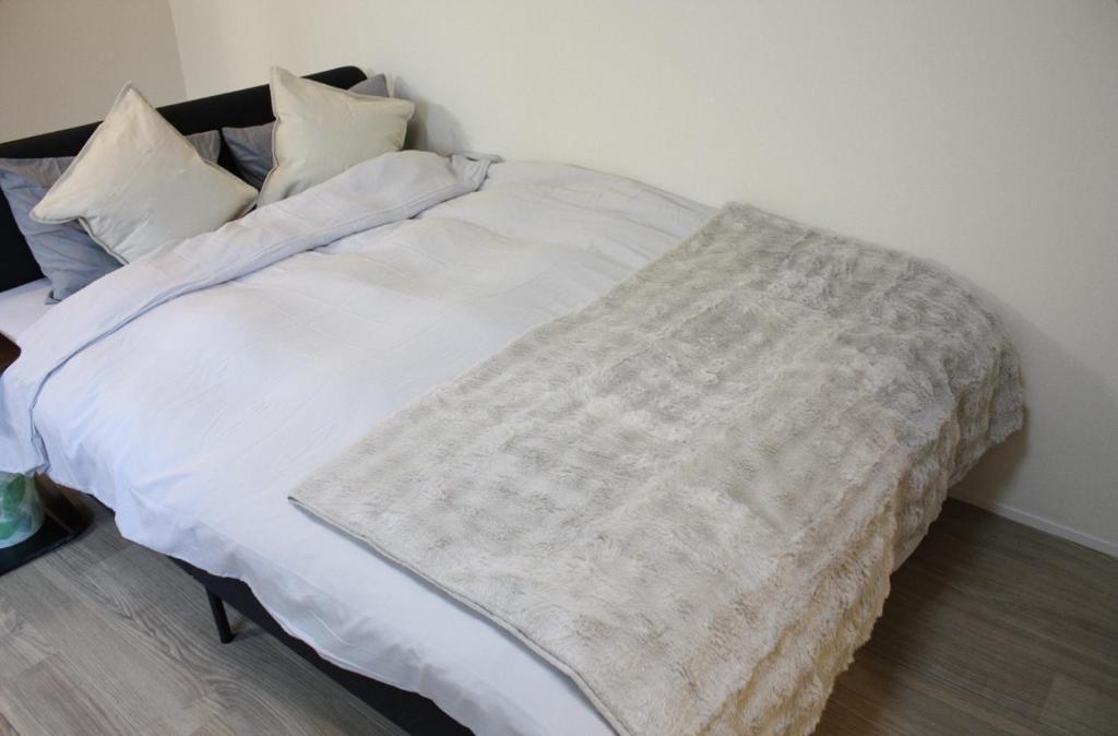 a bed with a blanket on it in a room at Jasmine House in Tokyo
