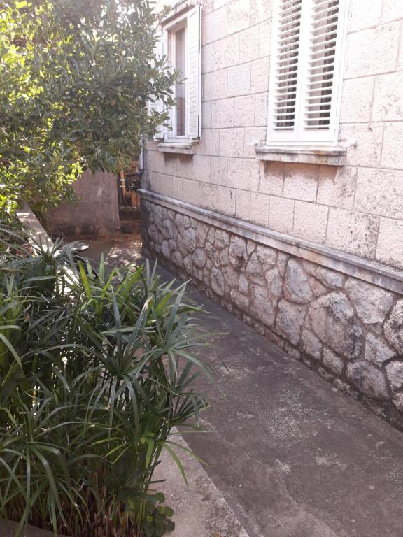 un mur en pierre à côté d'un bâtiment dans l'établissement Apartment Pavlito, à Dubrovnik