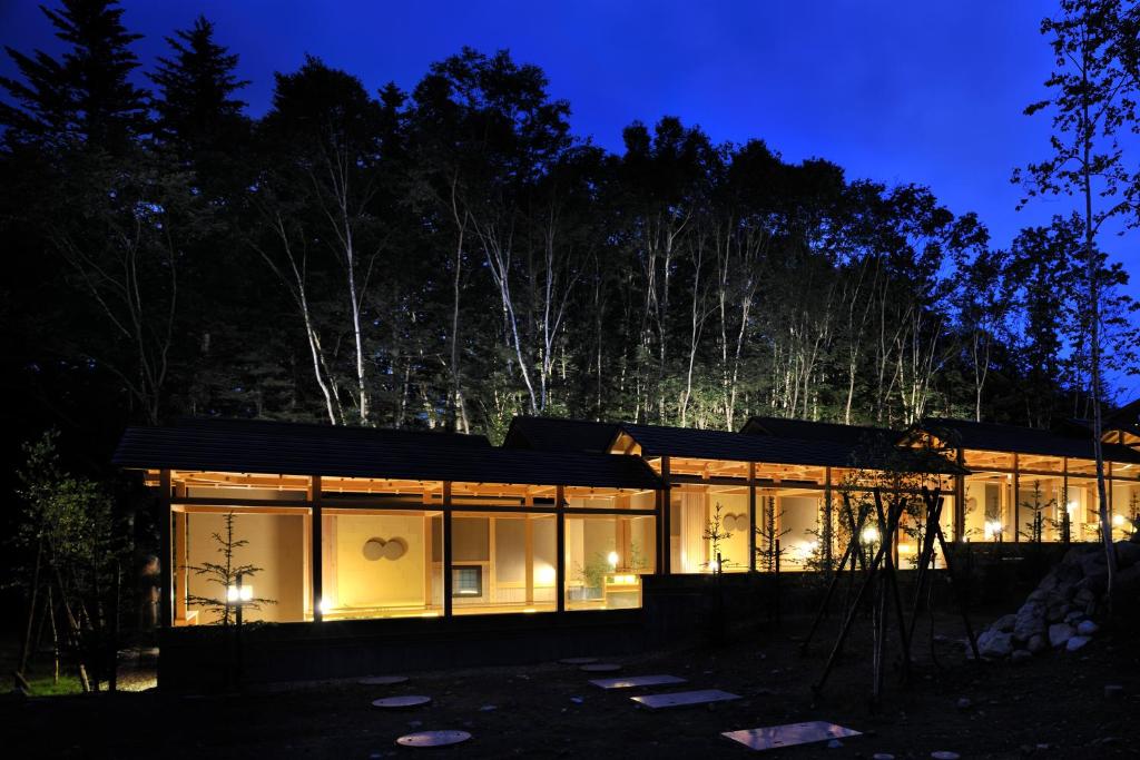 a house with glass windows at night at Morinoryotei Biei in Biei