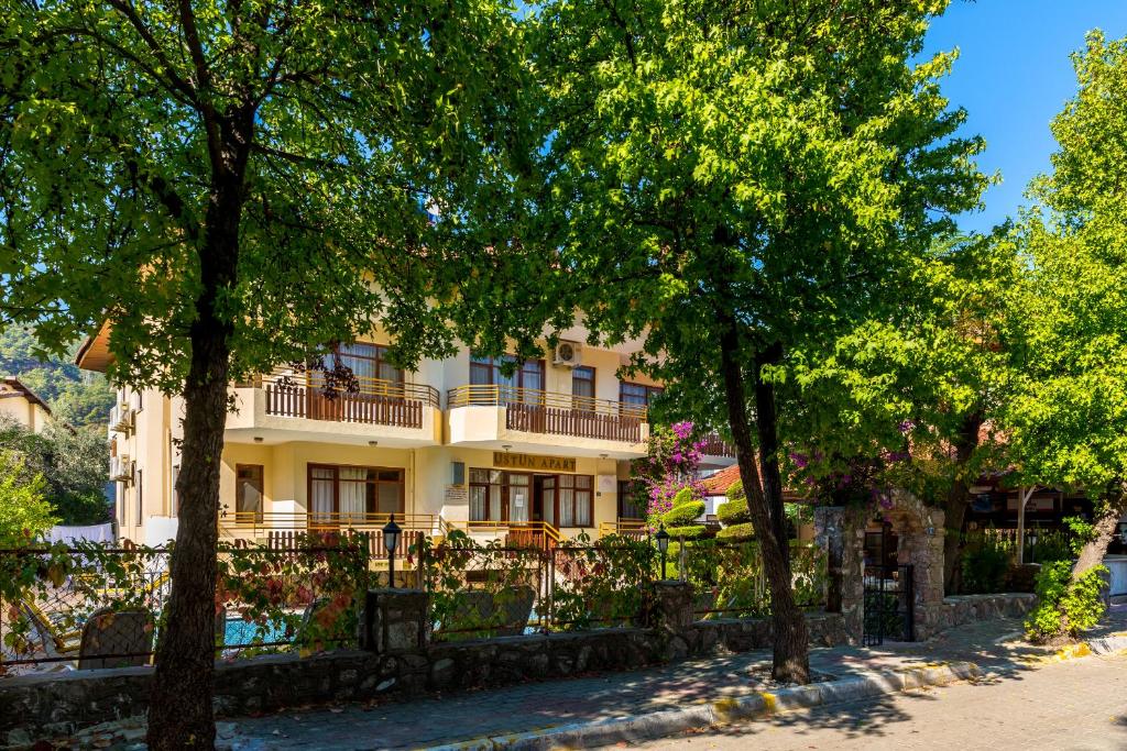 a building with a balcony in the middle of trees at Üstün Apart in Marmaris