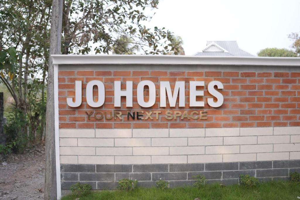 a sign on a brick wall that says jolin homes at Jo Homes Apartments in Alwaye