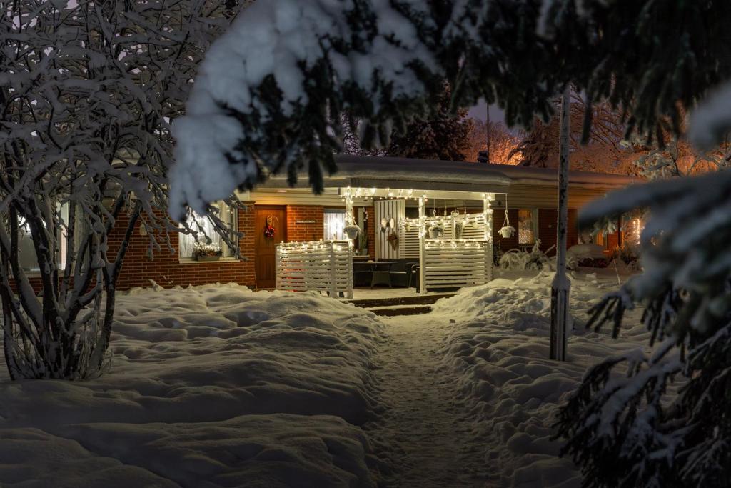 a house covered in snow at night at Rovaniemi Spacious Lapland Vacation Home with Private Sauna & Lappish Fire Hut in Rovaniemi