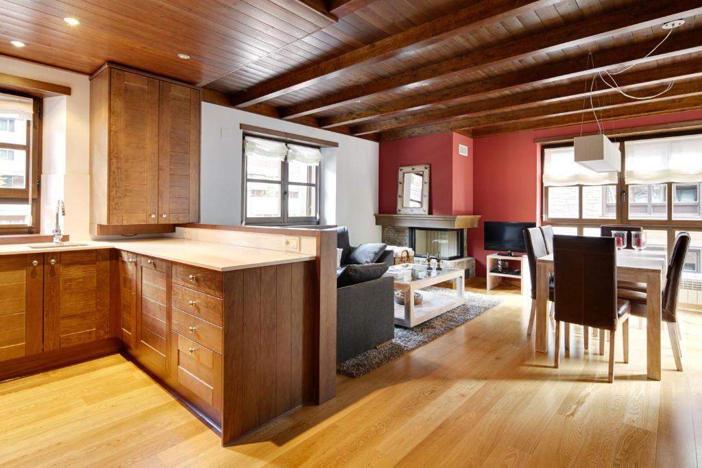 a kitchen with wooden cabinets and a dining room at Val de Ruda Luxe 21 by FeelFree Rentals in Baqueira-Beret