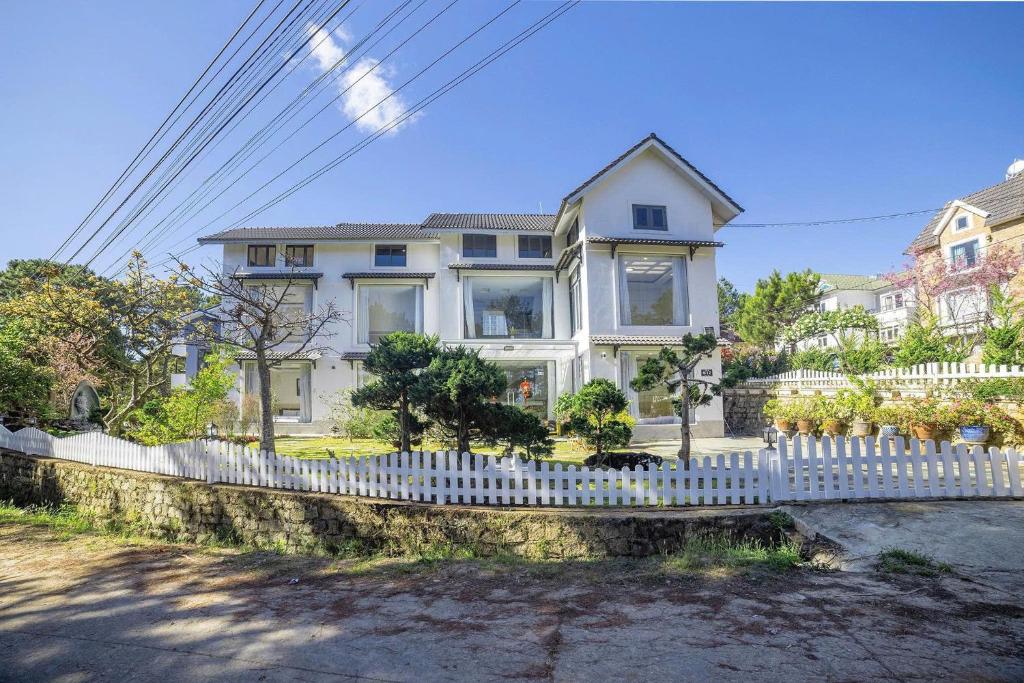 a white fence in front of a white house at Hamilton Villa Da Lat - Pine Tree n Valley View in Khu Chi Lăng