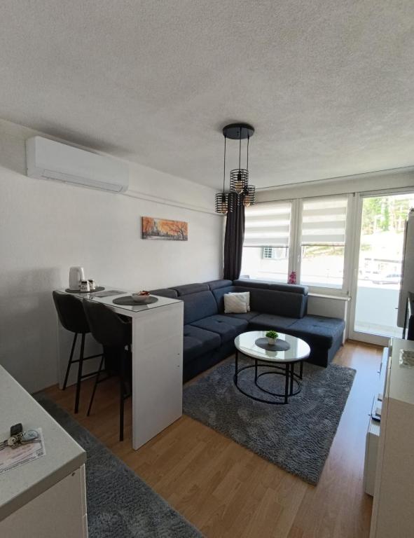 a living room with a blue couch and a table at Apartman City in Jajce