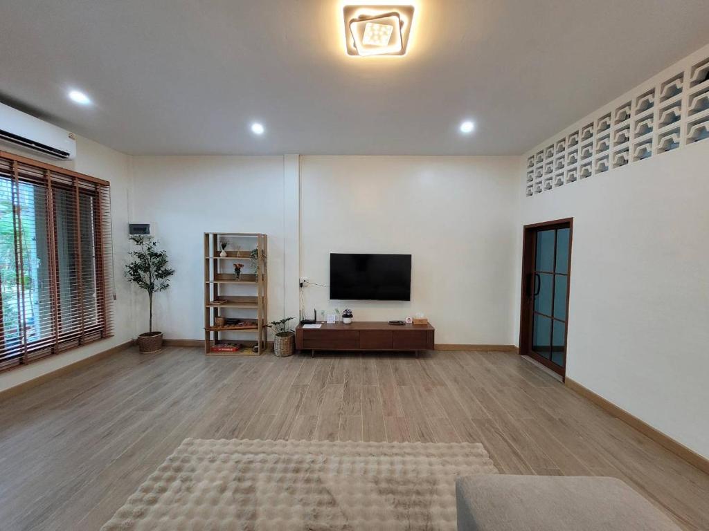 a large living room with a flat screen tv on a wall at Ama'home in Hat Yai