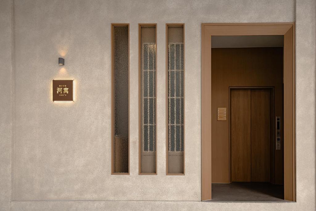 a building with a door and a sign on the wall at HOYU INN's in T'ien-liao