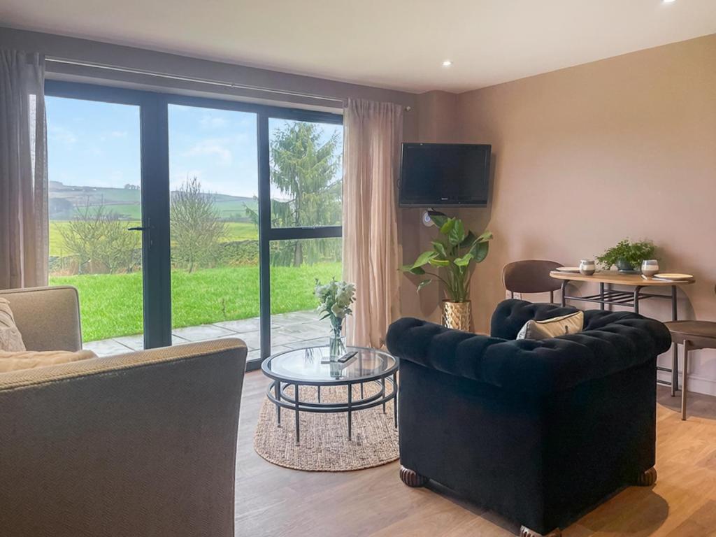 a living room with a couch and a table and a window at The Foxes Hole - Uk49085 in Winewall