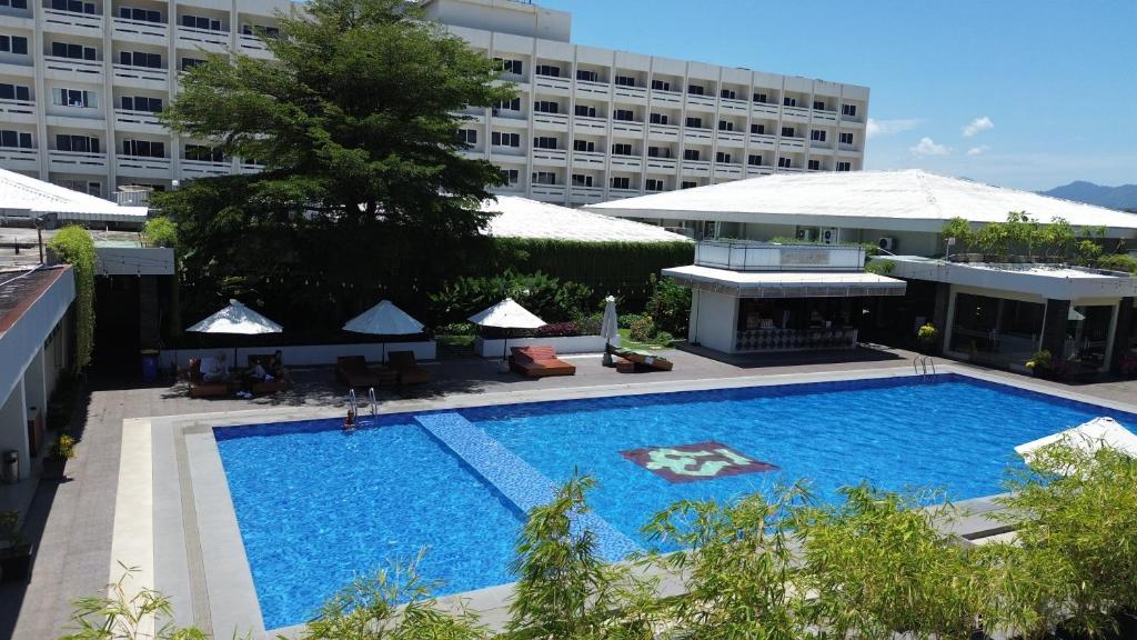 a large swimming pool next to a large building at Pangeran Beach Hotel in Padang